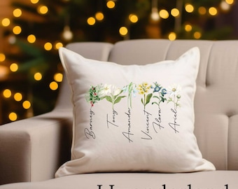 May include: A white throw pillow with a floral design and the names "Barrey", "Tony", "Amanda", "Vincent", "Flora", and "Ariel" written vertically on the front.