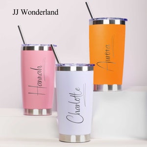 May include: Three stainless steel tumblers with lids and straws. The tumblers are pink, white, and orange. The names "Hannah", "Charlotte", and "Aurora" are engraved on the tumblers.
