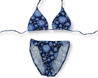 May include: A blue bikini with a floral print. The top is a triangle style and the bottom is a high-cut style.