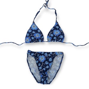 May include: A blue bikini with a floral print. The top is a triangle style and the bottom is a high-cut style.
