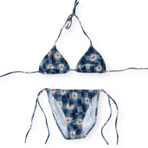 May include: A blue and white checked bikini with pink floral accents. The top is a triangle style and the bottom is a cheeky cut.