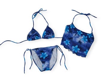 Può includere: Un bikini blu con stampa floreale. La parte superiore del bikini è di stile halter e la parte inferiore è di stile a lacci.