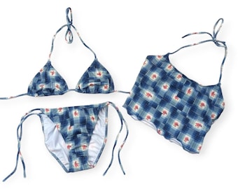 Può includere: Un set di bikini a stampa floreale blu e bianca con un top a triangolo e un fondo a vita alta.