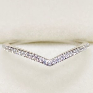 May include: A silver ring with a V-shaped band set with small clear stones.