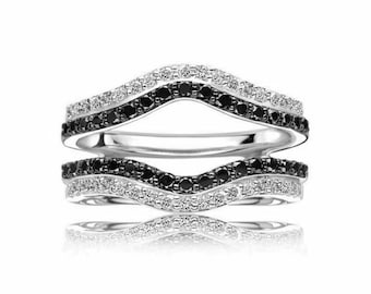 May include: Stackable sterling silver rings with a curved design. Each ring features a row of black gemstones between two rows of white gemstones. The rings are displayed on a white background with a reflection.