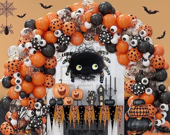 May include: Halloween party decorations with orange and black balloons, a black spider, and pumpkins. The balloons have a polka dot pattern and some have googly eyes.
