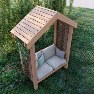May include: A wooden garden bench with a slatted roof and latticed side panels. The bench has two beige cushions and two throw pillows. The structure is surrounded by green grass and foliage, with red flowers in the foreground.