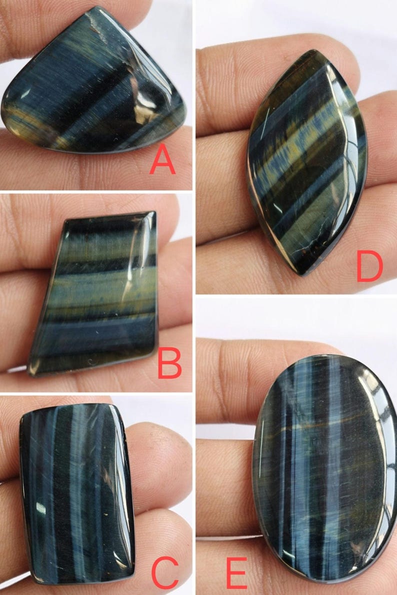 May include: Five different blue tiger's eye cabochons, each with a unique shape and pattern. The cabochons are displayed on a hand, with the letters A, B, C, D, and E labeling each stone.
