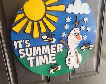 May include: A round wooden sign with a blue sky background, a yellow sun, and the text "IT'S SUMMER TIME". The sign features a cartoon snowman, snowflakes, and bees. A jute rope is attached for hanging.