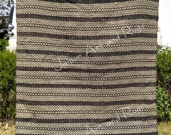 May include: A black and white striped rug with a geometric pattern. The rug is made of natural fibers and has a fringed edge.