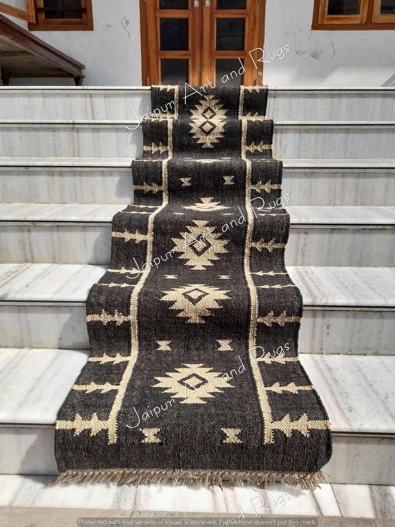 May include: A black and cream patterned rug with fringe on the edges. The rug is laid out on a set of stairs.