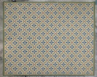 May include: A beige rug with a repeating geometric pattern in shades of blue, green, and red. The pattern features stylized flowers and squares.