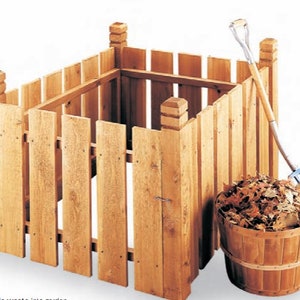 Pode incluir: Um recipiente de compostagem de madeira com formato quadrado, construído com tábuas verticais e postes de canto. Uma cesta de madeira cheia de folhas secas está ao lado do recipiente, com um forcado encostado. O recipiente é projetado para compostar resíduos orgânicos.