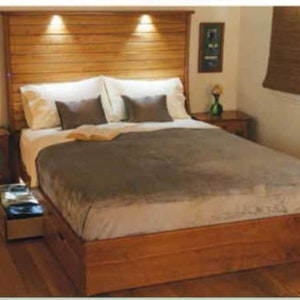 Può includere: Un letto con struttura in legno e testata con luci integrate. Il letto ha un piumone grigio e cuscini bianchi. Il letto si trova in una camera da letto con un comodino in legno e un piccolo quadro appeso al muro.