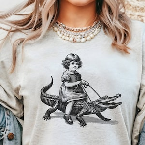 cool vintage retro tshirt thathas a little girl riding on a alligator graphic