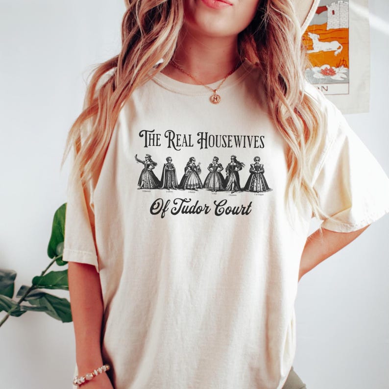 The Real Housewives of Tudor Court
If you're a history enthusiast with humor, the "Real Housewives of Tudor Court" shirt is a must-have addition to your collection. This cleverly designed shirt showcases the six wives of Henry VIII, that dramatically shaped the course of English history. From the steadfast Catherine of Aragon to the tragic Anne Boleyn, and the demure Jane Seymour to the resilient Anne of Cleves, the shirt humorously encapsulates the lives of these historical figures.