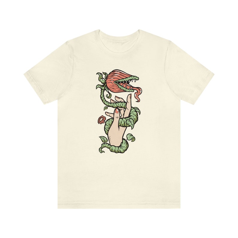 May include: A white t-shirt with a graphic of a hand holding a carnivorous plant with a red flower and green vines.