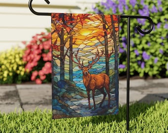 May include: A stained glass style garden flag featuring a deer standing in a forest with a sunset in the background.