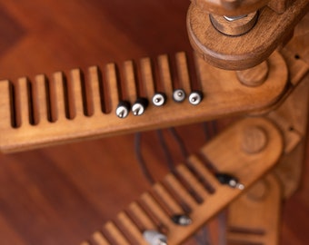 May include: A wooden cable organizer with multiple tiers and slots for holding various cables and cords. The organizer is made of natural wood and has a rustic, handcrafted look.