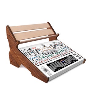 Könnte beinhalten: Ein Holz-Synthesizer mit einer hellen Holzplatte und einem dunklen Holzrahmen. Die Vorderseite des Synthesizers ist weiß mit verschiedenen farbigen Knöpfen und Tasten. Der Text "SOLAR 42" ist auf der Vorderseite zu sehen.
