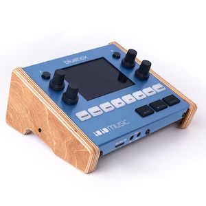 May include: A blue music production device with a small screen and knobs. The device is made by 1010 music and is called "bluebox".