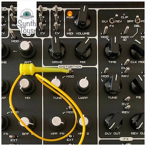May include: A black and silver synthesizer with a yellow patch cable connected to the distortion knob. The synthesizer has knobs labeled "Drive", "Mix", "Time", "Tune", "Warp", "Mod", "Rev", "CLK MOD", "BPF", "HPF FR", "HPQ", "DLY OUT", "REV OUT", and "FX".
