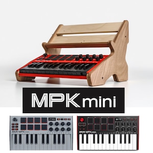 May include: A red and black MPK mini keyboard with black keys and control knobs, set in a wooden stand. The stand is made of light-colored wood. The text "MPK mini" is displayed in white on a black background.