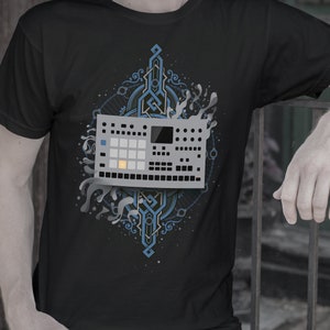 May include: Black t-shirt featuring a gray electronic music production device graphic with blue and white accents. The design includes a geometric pattern and water-like elements. The shirt is a crew neck.