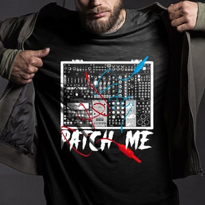 May include: A black t-shirt with a graphic of a synthesizer with red and blue patch cables. The text "PATCH ME" is below the synthesizer.