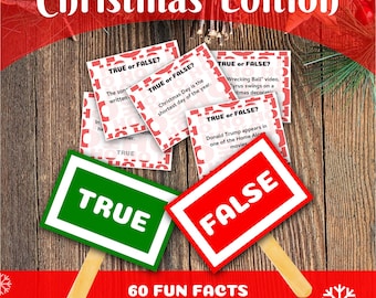 Könnte beinhalten: Ein Set mit 60 Weihnachts-Quizkarten mit einem rot-weißen "Wahr oder Falsch?"-Design. Die Karten liegen auf einer Holzoberfläche mit einem grünen "Wahr"-Schild und einem roten "Falsch"-Schild. Der Text auf den Karten enthält Quizfragen zu Weihnachtsbräuchen und Fakten.