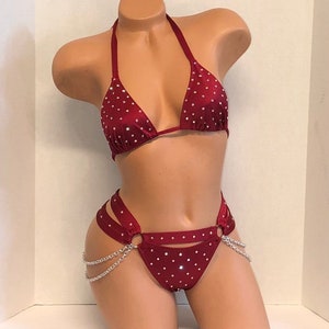 May include: A burgundy two-piece lingerie set with silver chains and rhinestones.