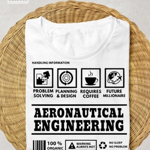 May include: White t-shirt with a black graphic design that says "Aeronautical Engineering". The graphic includes icons for problem solving, planning and design, coffee, and a globe with airplanes. The text "100% Organic", "Warning Always Hot", and "No Sleep No Problem" is also included in the design.