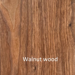May include: Close-up of walnut wood grain. The wood has a warm brown color with vertical lines and natural patterns. The text "Walnut wood" is displayed in white at the bottom of the image.
