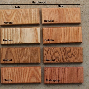 Puede incluir: Muestras de madera en cuatro acabados diferentes: natural, dorado, nogal y cerezo. Las muestras est&aacute;n dispuestas en dos filas de cuatro, con el tipo de madera etiquetado encima de cada fila. Los tipos de madera son Fresno y Roble.