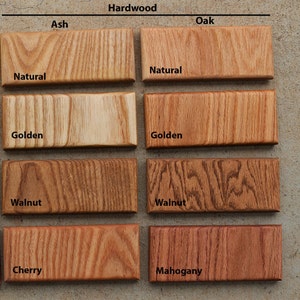 May include: A collection of hardwood samples, including Ash and Oak, with various finishes. The samples are labeled with the wood type and finish, such as "Natural," "Golden," "Walnut," "Cherry," and "Mahogany." The samples are rectangular and display the wood grain.