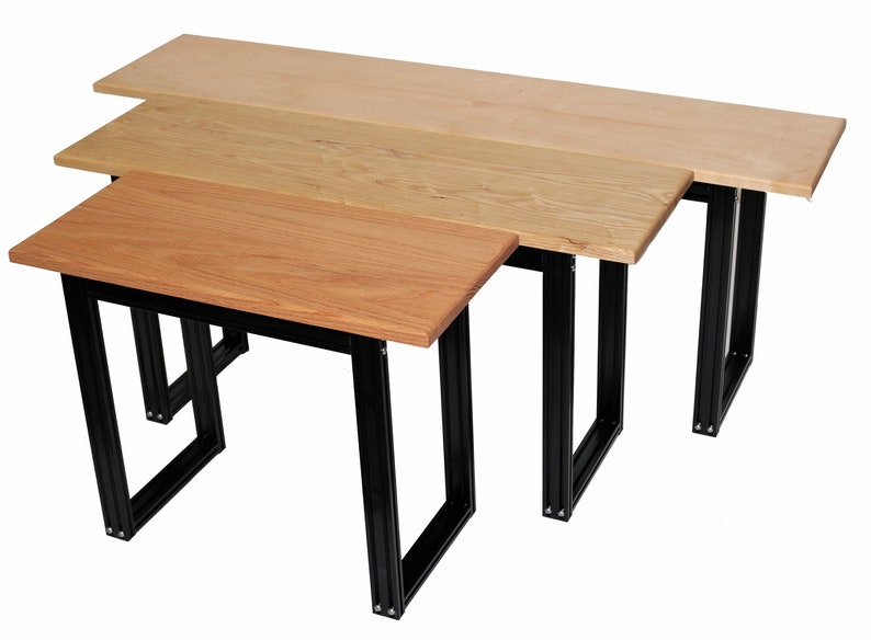 Puede incluir: Tres encimeras de mesa de madera de diferentes tama&ntilde;os, cada una con un marco de metal negro. Las encimeras de mesa est&aacute;n apiladas una encima de la otra, con la encimera m&aacute;s grande en la parte inferior y la encimera m&aacute;s peque&ntilde;a en la parte superior.