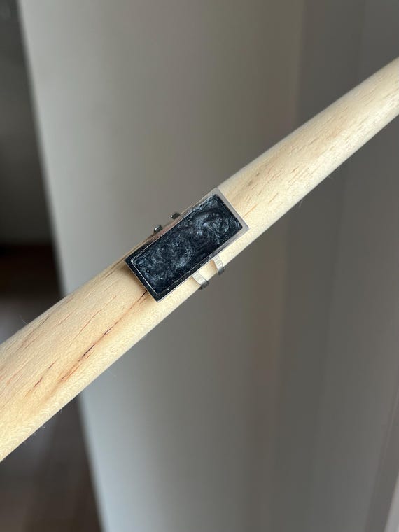 Large rectangular ring with silver stainless steel setting and shimmering dark grey epoxy resin