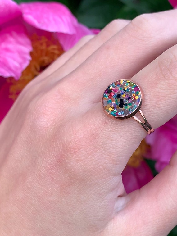 Ring made of rose gold metal with transparent resin the colorful glitter