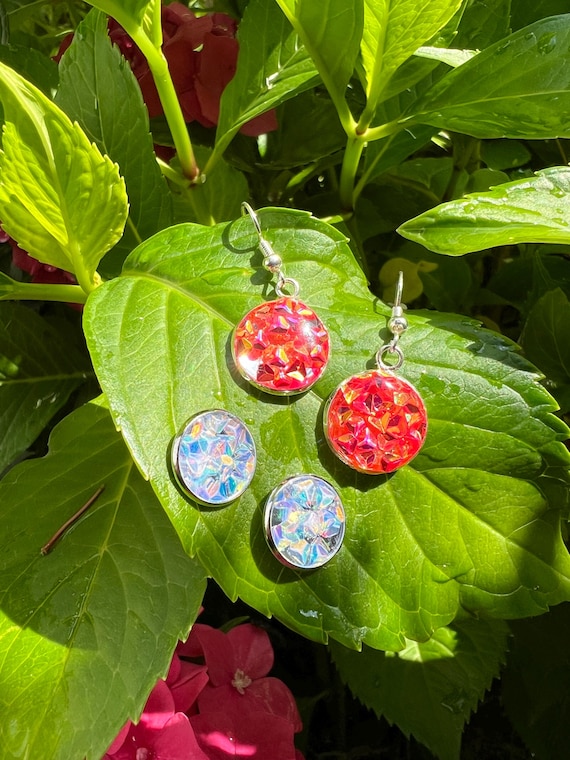 Earrings in metal setting made of cast resin in orange and white glitter
