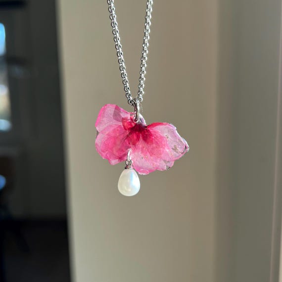 Necklace pendant made of a real pink cherry blossom with a white artificial pearl and silver clasp