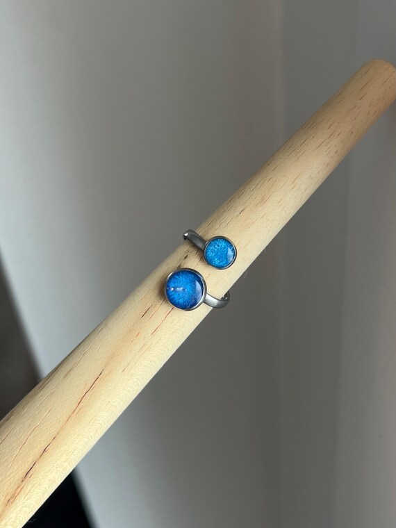 Double ring in silver stainless steel setting and shimmering blue tones made of epoxy resin, adjustable in size