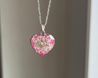 Love pendant Herzform Edelstahl in Silber pinker Glitzerhintergrund mit weißen echten Blumen real flower jewelry