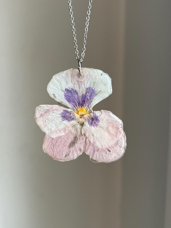 Necklace pendant made of a real white pansy flower with purple details and silver clasp