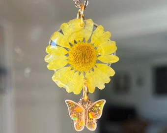 Kettenanhänger aus einer echten gelben Margheritenblüte mit goldenem Verschluss und Schmetterling Charm Glitzer