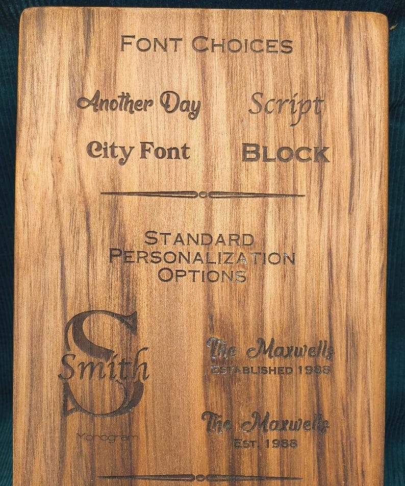 Pu&ograve; includere: Una tavola di legno rettangolare con testo ed esempi incisi al laser. La sezione superiore mostra FONT CHOICES tra cui Another Day, Script, City Font e BLOCK. Sotto, STANDARD PERSONALIZATION OPTIONS presenta esempi di Smith e The Maxwells.