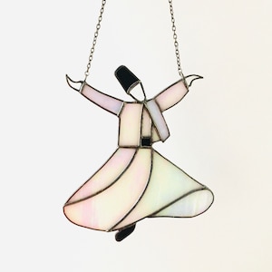 May include: A stained glass hanging of a whirling dervish, a figure in a white robe with a black hat, with a chain for hanging.