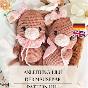 Könnte beinhalten: Zwei gehäkelte Mäusebären in einem Korb. Die Bären sind hellbraun mit rosa Akzenten an Ohren, Schleifen und Kragen. Der Text auf dem Bild lautet: "ANLEITUNG LILU DER MÄUSEBÄR PATTERN LILU THE MOUSE BEAR".