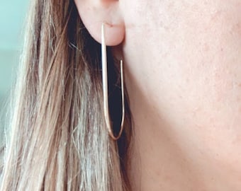 May include: A pair of gold oval hoop earrings. The earrings are simple and elegant, and they would be a great addition to any jewelry collection.