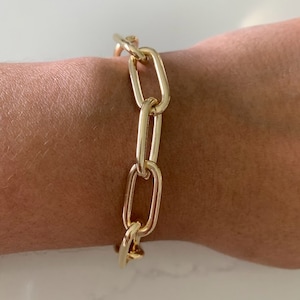 May include: A gold chain bracelet with large oval links.
