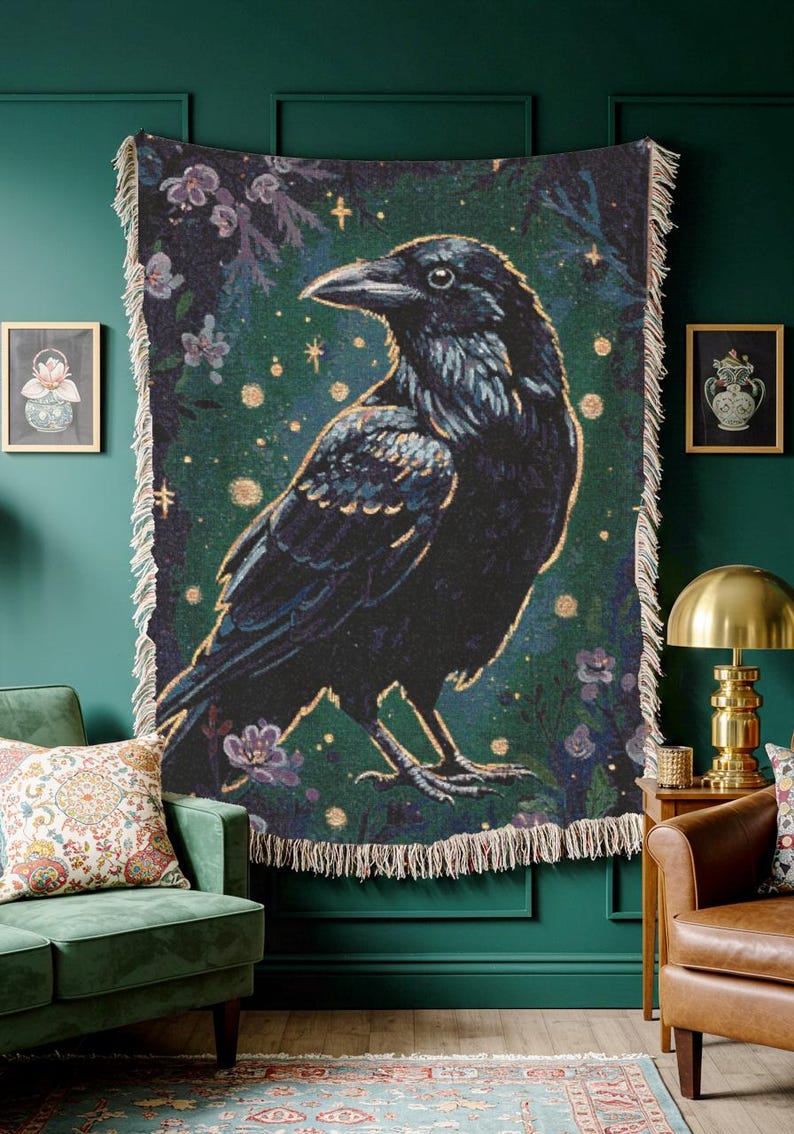 Raven woven blanket with a side profile of a raven with a yellow highlight around it a teal background and flowers in the corners witchy tapestry